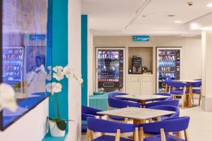 een restaurant met blauwe tafels en blauwe stoelen bij AHOI! Urban Beach in Palma de Mallorca