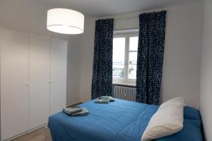 um quarto com uma cama azul e uma janela em Casa Zaffiro em Savigliano