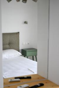 a bedroom with a bed and a green table at Makis Sea View Studios in Skiathos Town