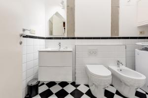 La salle de bains blanche est pourvue de toilettes et d'un lavabo. dans l'établissement Tornabuoni City Center Florence, à Florence