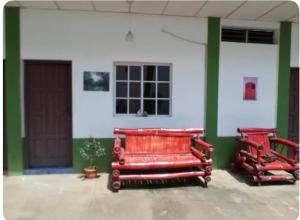 two red benches sitting in front of a building at 31 ave home stay in Managua