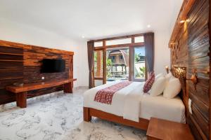 une chambre avec un grand lit et une télévision dans l'établissement Golden Lotus Deluxe Studio, à Canggu