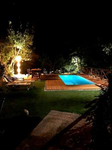 a backyard with a swimming pool at night at La Dimora dei Baldi - Rooms & Relax in Fagnano Alto