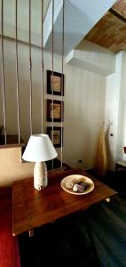 a table with a lamp and a plate on it at La Dimora dei Baldi - Rooms & Relax in Fagnano Alto