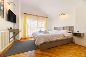a bedroom with a large bed and a large window at Pensiunea Casa Bono - Cazare Brasov in Braşov