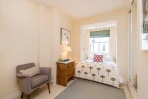 1 dormitorio con 1 cama y 1 silla en Delightful 2 Bed in Notting Hill - 5 min from tube en Londres