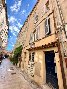 stary budynek z niebieskimi drzwiami na ulicy w obiekcie Cepoun - Grand studio centre Saint-Tropez w Saint-Tropez