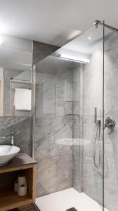 W łazience znajduje się prysznic i umywalka. w obiekcie Hotel La Montanara Predazzo w mieście Predazzo