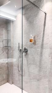 y baño con ducha y puerta de cristal. en Hotel La Montanara Predazzo, en Predazzo