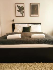 a black and white bed with two pillows on it at CozyHome Signature Palisady Apartment in Bratislava