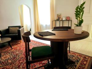 een woonkamer met een houten tafel en een stoel bij CozyHome Signature Palisady Apartment in Bratislava