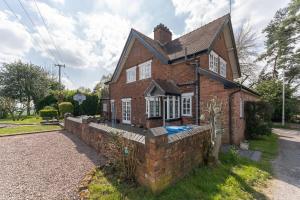 a brick house with a swimming pool in front of it at Beautiful country cottage for 8 - great staycation in Wolverhampton