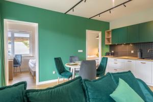 a kitchen and a living room with a table and chairs at Apartament Izerka z Sauną in Świeradów-Zdrój
