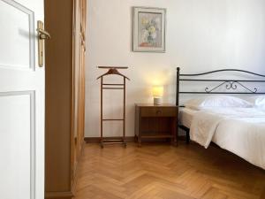 um quarto com uma cama e uma mesa com um candeeiro em Gli Acquerelli em Trieste