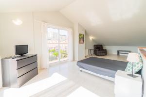 a bedroom with a bed and a tv and a window at Casa para vacaciones perfectas in Vilassar de Mar