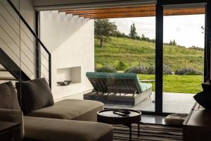 a living room with a couch and chairs and a large window at Land of Alandroal in Évora