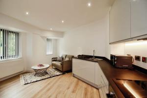 cocina y sala de estar con sofá en Seven Stays Modern Studio Apartment - Solihull, en Solihull