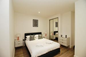 1 dormitorio con cama y espejo grande en Seven Stays Modern Studio Apartment - Solihull, en Solihull