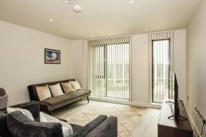 a living room with a couch and a tv at St Martin's Place Apartment - Bham City Centre in Birmingham