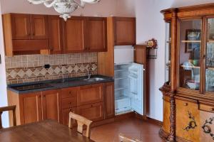 a kitchen with wooden cabinets and an open refrigerator at Bari Sardo Suite Padronale in Bari Sardo +21 photos