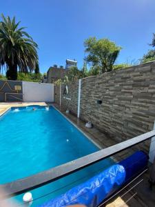 a large blue swimming pool next to a brick wall at Doña Margarita in Chascomús