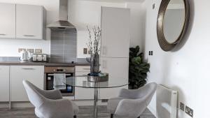 a kitchen with a glass table and two chairs at Luxury 2 Bed Apt - 15 Mins to Central Birmingham in Birmingham