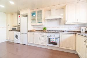 a kitchen with white cabinets and a washer and dryer at Casa para vacaciones perfectas in Vilassar de Mar