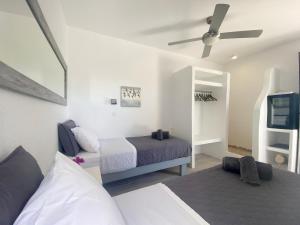 a bedroom with a bed and a ceiling fan at Two level house on the Beach in Agios Ioannis Mykonos