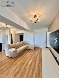 een woonkamer met een bank en een flatscreen-tv bij Lamera-Miraj sea view in Mamaia