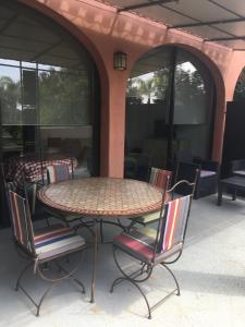 une table et des chaises sur une terrasse avec une table dans l'établissement Domaine la Colomine, à Canet