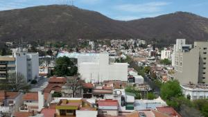 a city with buildings and a mountain in the background at Departamento Dean Funes in Salta