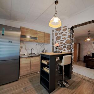 una cucina con frigorifero e bancone con sedia di Unique Apartment Centar a Podgorica Altre 7 foto