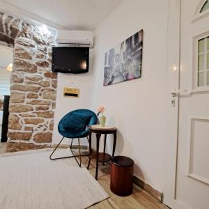 una camera con una sedia blu e un tavolino di Unique Apartment Centar a Podgorica