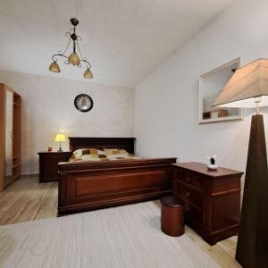 una camera da letto con un letto e un orologio sul muro di Unique Apartment Centar a Podgorica