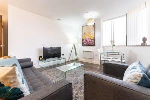 a living room with two couches and a table at SevenStays Bham city centre 1 bed - free parking in Birmingham