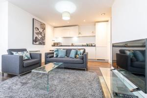 a living room with two couches and a glass table at SevenStays Bham city centre 1 bed - free parking in Birmingham