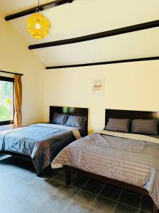 1 dormitorio con 2 camas y ventana en Eleven villa 2 en Pangandaran