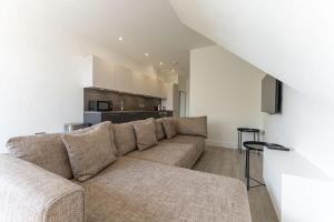 a living room with a couch and a kitchen at Contemporary 2 Bed Apartment Solihull NEC BHX in Solihull