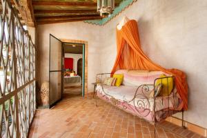 um quarto com uma cama e uma rede mosquiteira laranja em La Agüita em playa del Águila
