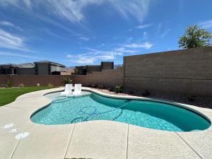 a swimming pool in a yard with a brick wall at Desert Gem - Mesquite in Mesquite
