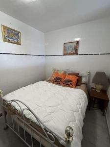 um quarto com uma cama com almofadas laranja em Appartement sur la plage em Pléneuf-Val-André