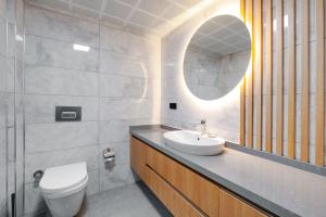 a bathroom with a sink and a toilet and a mirror at Krem Marin Suites Otel in Cesme