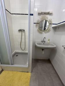 uma casa de banho com um chuveiro, um lavatório e um espelho. em Appartement sur la plage em Pléneuf-Val-André
