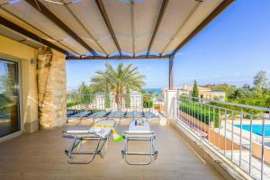 a patio with chairs and a table and a pool at Villa Paralia in Polis Chrysochous