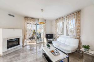 a living room with a white couch and a fireplace at Villa Paralia in Polis Chrysochous