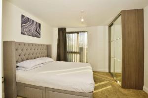 een slaapkamer met een groot wit bed en een raam bij Contemporary 2 bedroom apartment - Ashford in Ashford