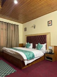 - une chambre avec un grand lit dans l'établissement Vamika Cottages, à Manali