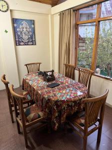 a dining room table with a laptop on top of it at Vamika Cottages in Manāli