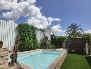 una piscina en un jardín con una fuente en El molino del abuelo, en Montecorto