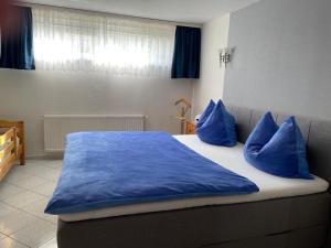 a bedroom with a bed with blue pillows on it at Ferienwohnung Behrens in Celle